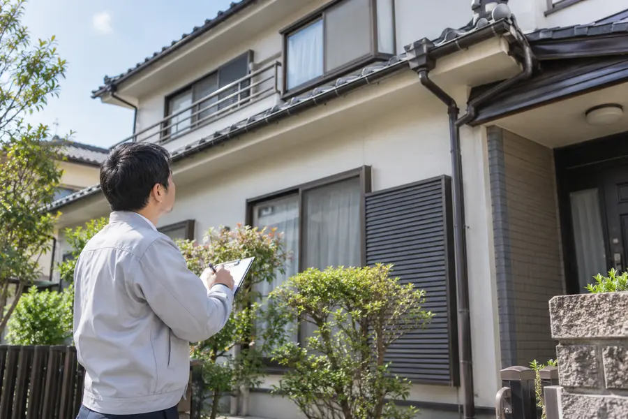 現地確認で家全体の状態を見ている担当者