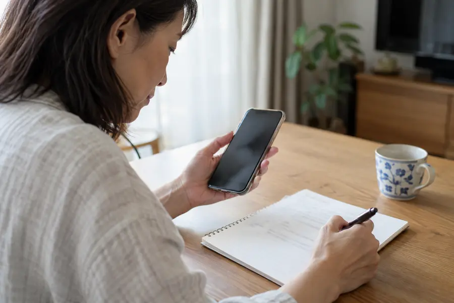 不具合の内容を書き出したメモとスマートフォン